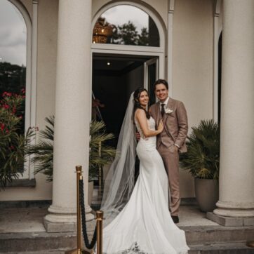 Echte bruid Laurien in aansluitende kanten trouwjurk van Figen Bridal Boutique samen met bruidegom op trouwdag